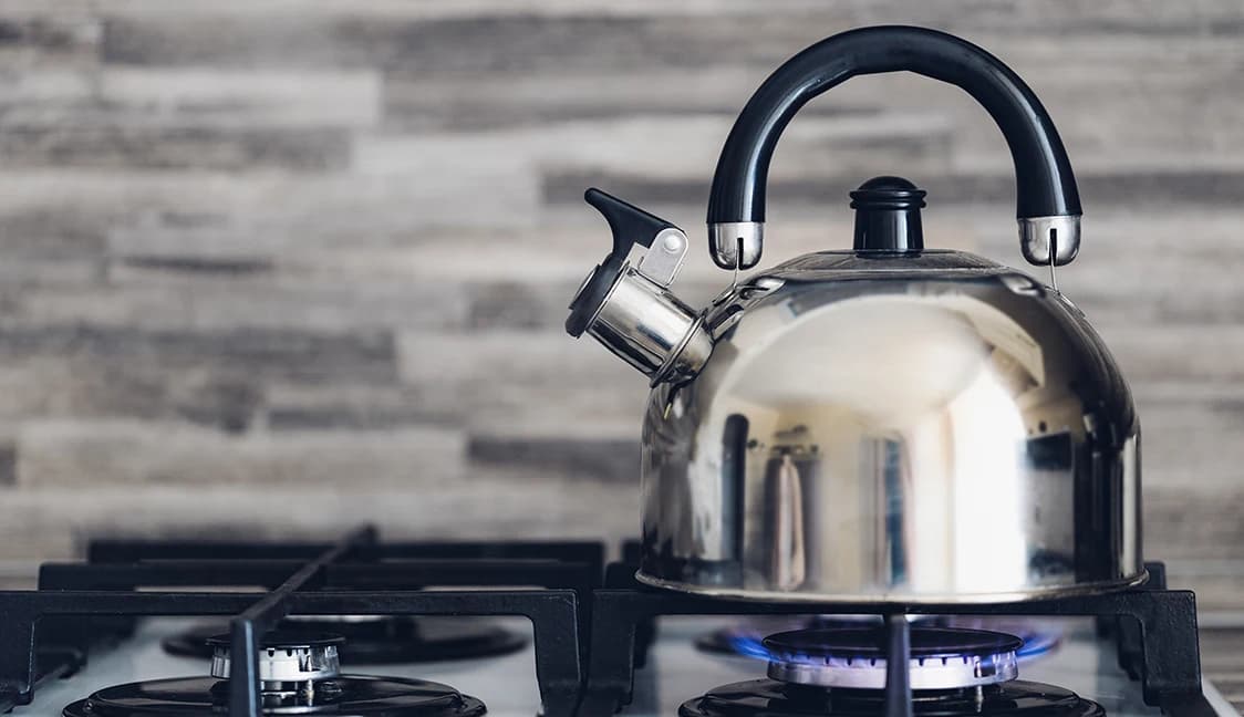 Kettle being heated on a gas stove top