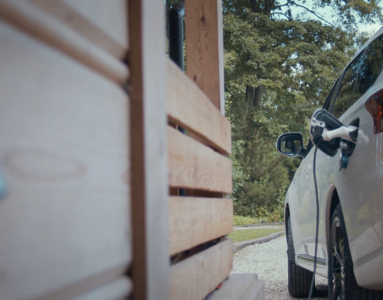 A white electric vehicle plugged in for charging